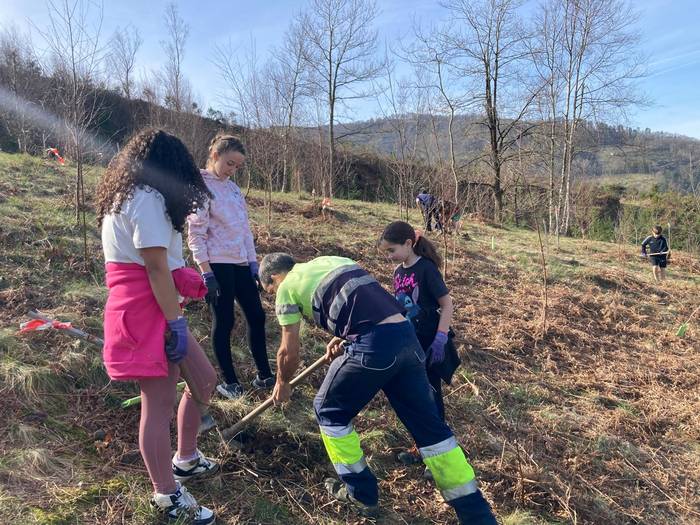 Dozenaka ikaslek zuhaitzak landatu dituzte Munoaundiko basoan